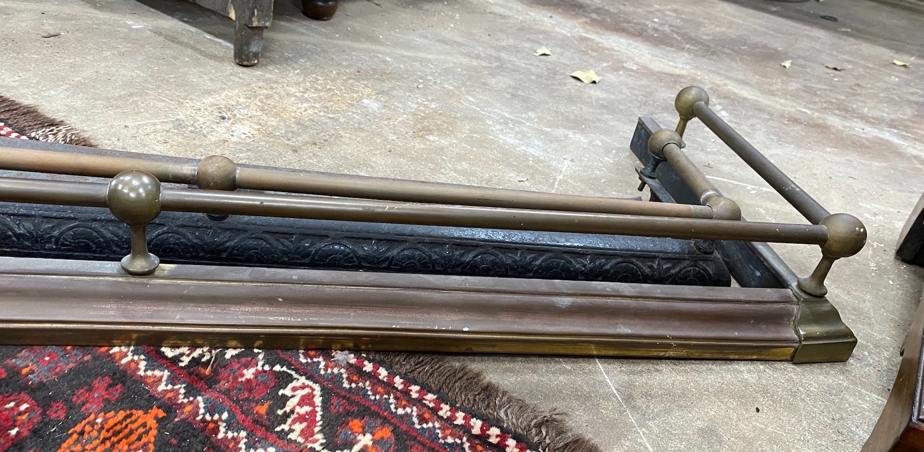 A Victorian iron and brass fender, length 104cm, together with a larger later brass fender
